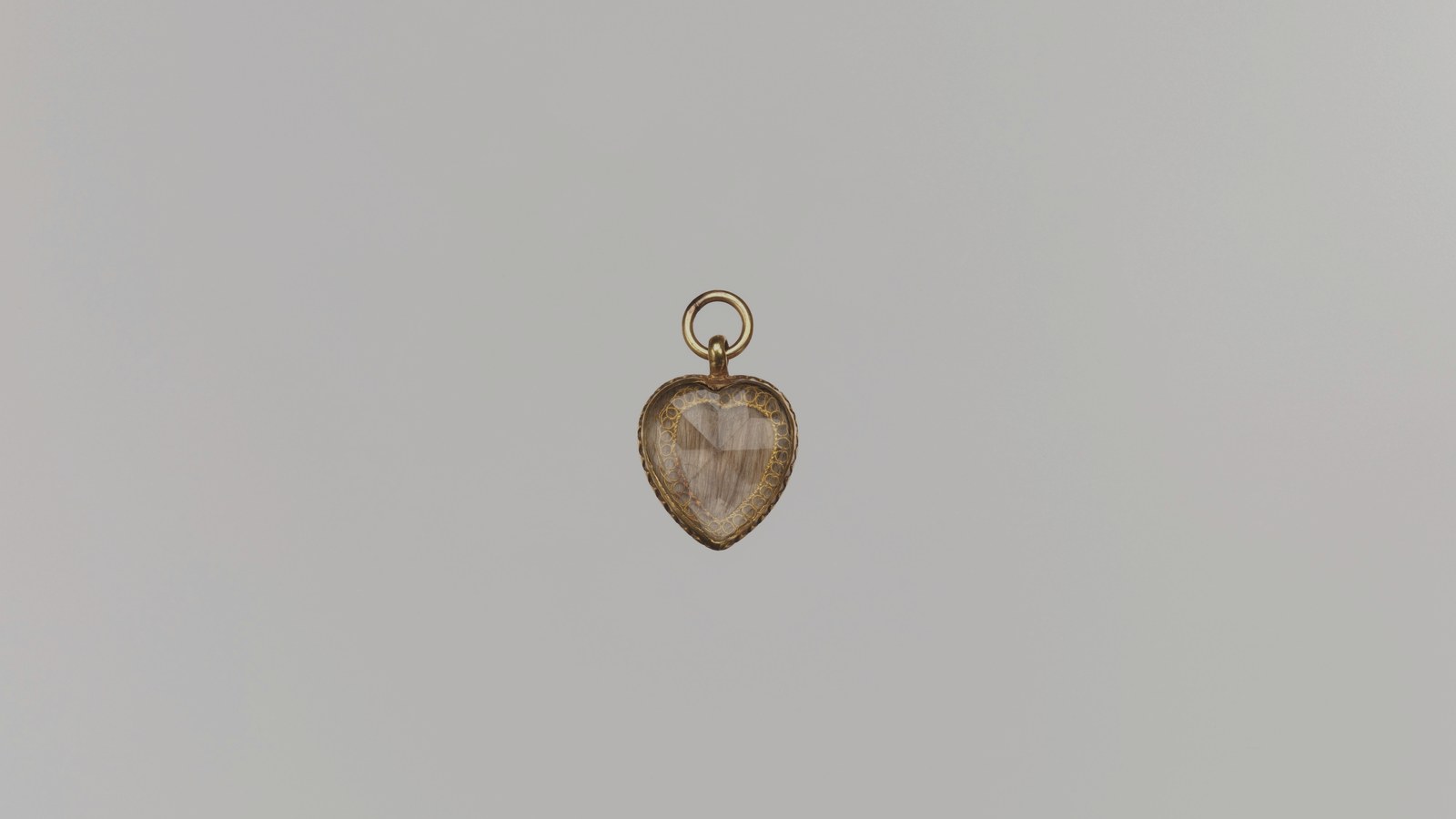 Gold heart-shaped locket from 1706, with hair under crystal