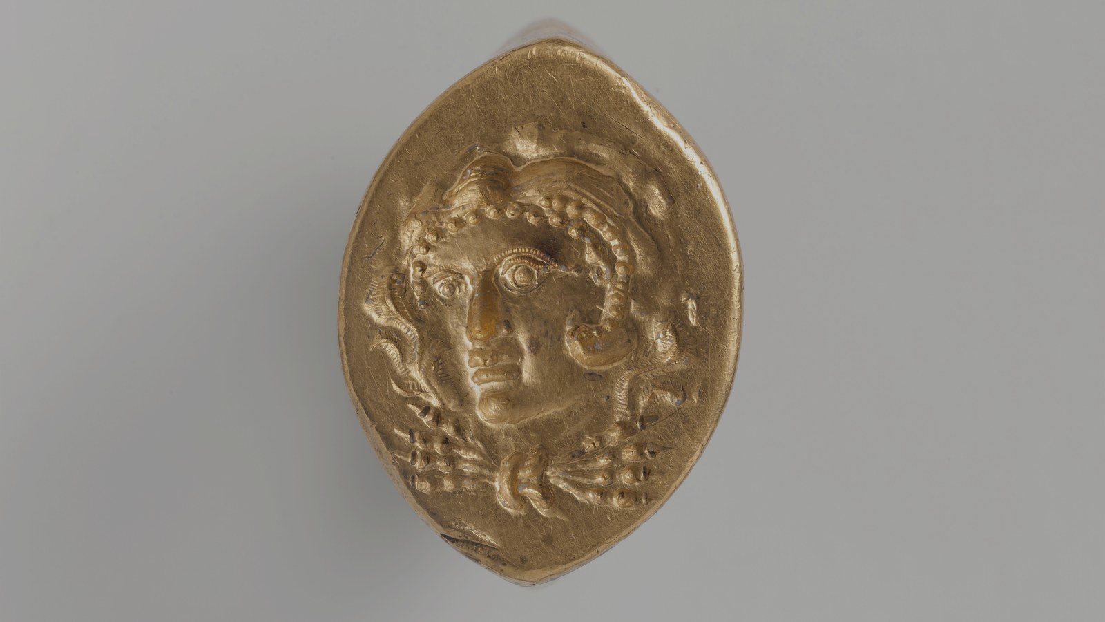 Ancient gold ring with a carved head on the bezel
