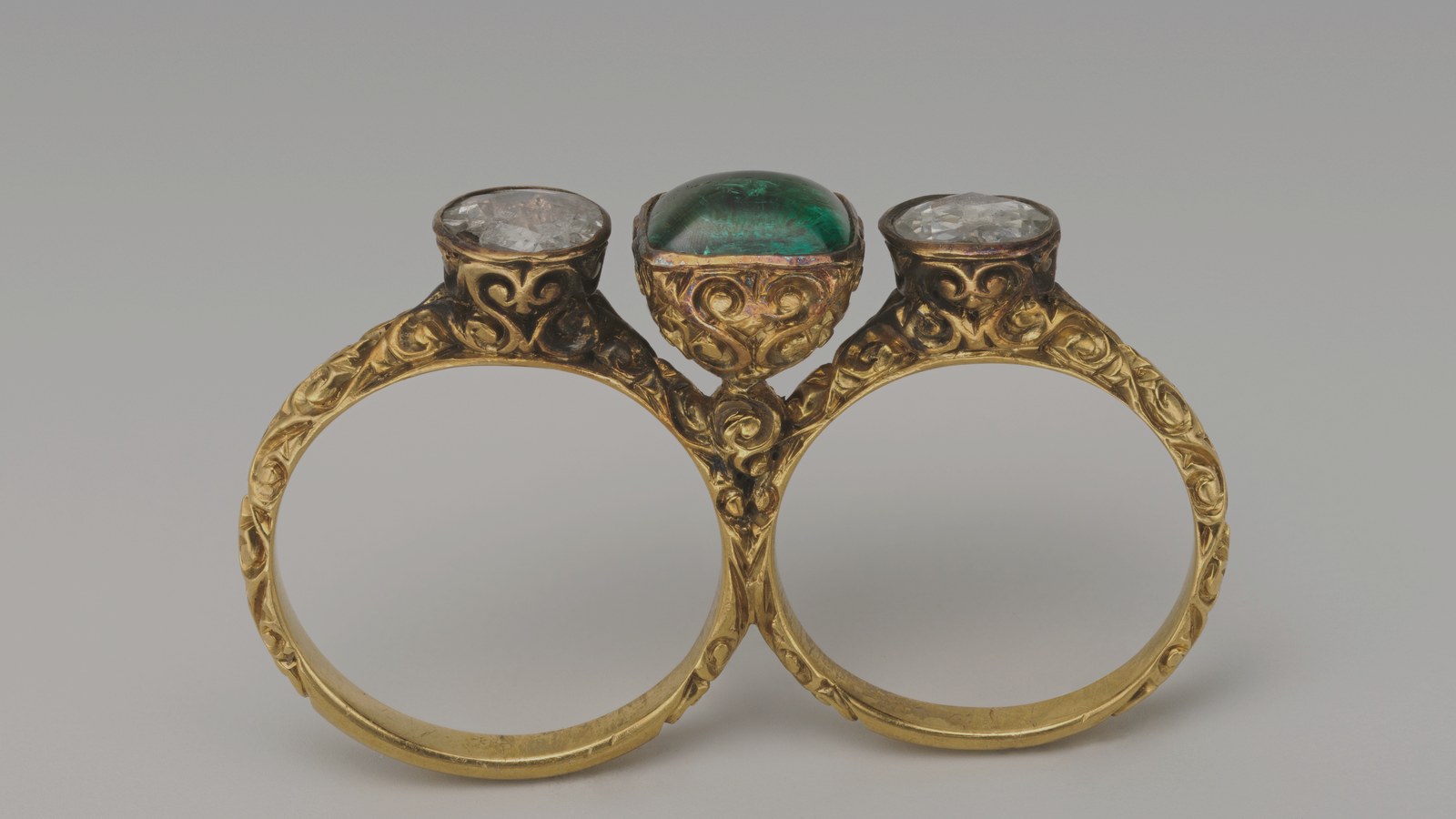 Gold double ring set with diamonds and an emerald, about 1895